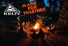 Enjoying a campfire with friends in a forest setting at night, surrounded by tents and outdoor gear.